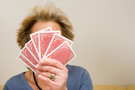 Senior woman holding playing cardsの写真素材