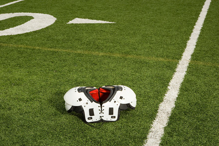 Shoulder pads on football fieldの写真素材