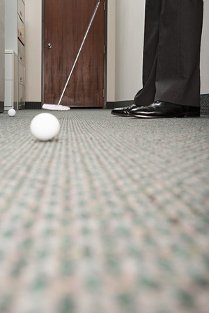 Business man practicing putting