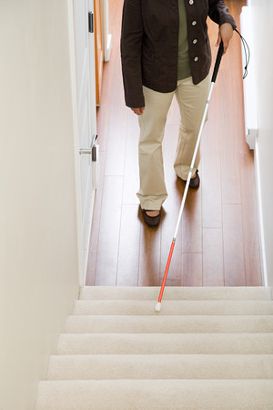 Blind woman using a walking stick on stairwayの写真素材