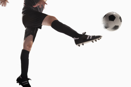 Athlete kicking soccer ball