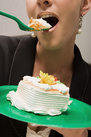 Businesswoman eating cake