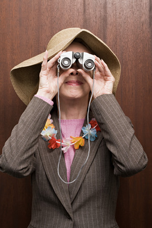 Business woman looking through binocularsの写真素材