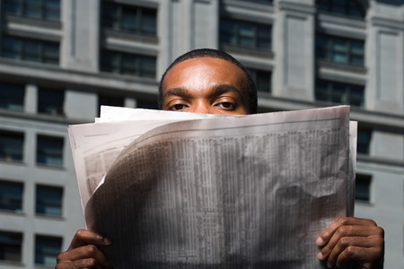 Man looking over newspaperの写真素材