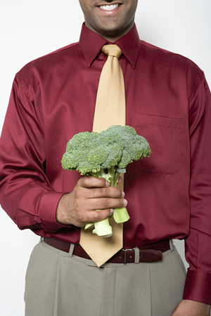 Man holding a bunch of broccoliの写真素材
