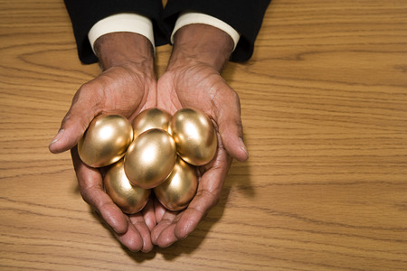 Man holding golden eggsの写真素材