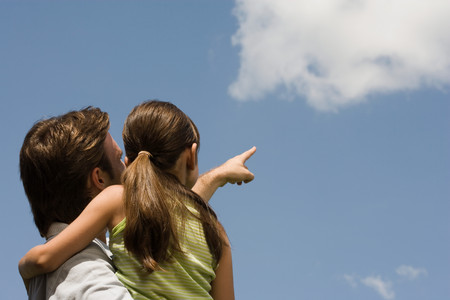 Father and daughter looking at cloudの写真素材