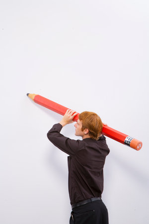 Man holding large pencilの写真素材