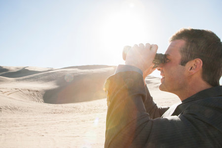 Businessman with binocularsの写真素材
