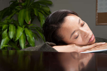 Business person asleep in officeの写真素材