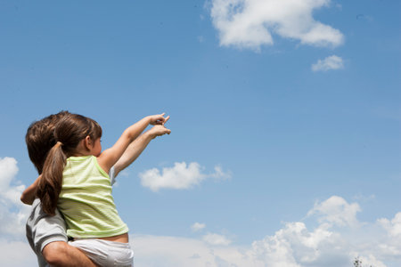Father and daughter pointing to cloudsの写真素材