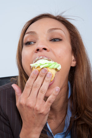 Business colleagues eating cupcakes in officeの写真素材