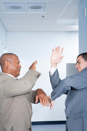 Businessmen fighting in officeの写真素材