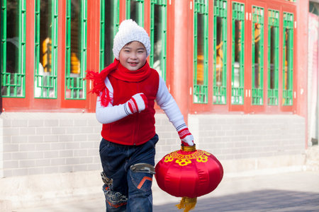 Boy holding lantern dressed in holiday attireの写真素材