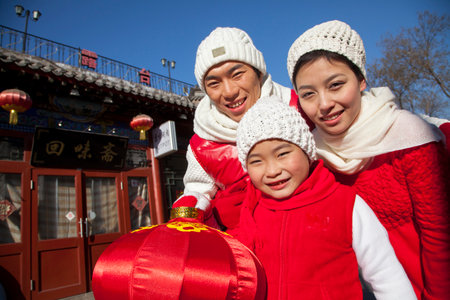 Family holding lantern dressed in holiday attireの写真素材