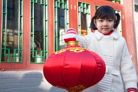 Girl holding lantern dressed in holiday attireの写真素材