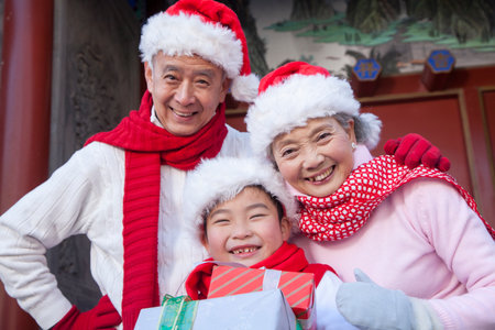 Family holding gifts dressed in holiday attireの写真素材