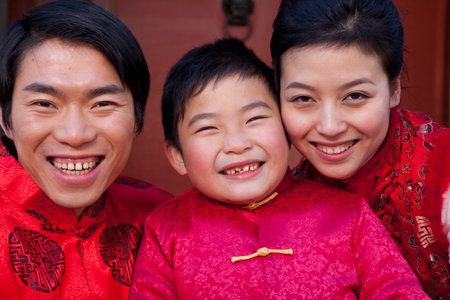 Family dressed in holiday attire in front of houseの写真素材