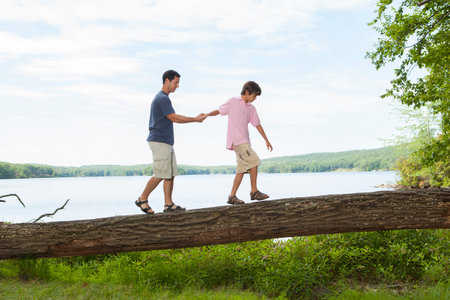 Father and son walking next to lake togetherの写真素材