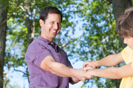Father and son climbing on rock together in natureの写真素材