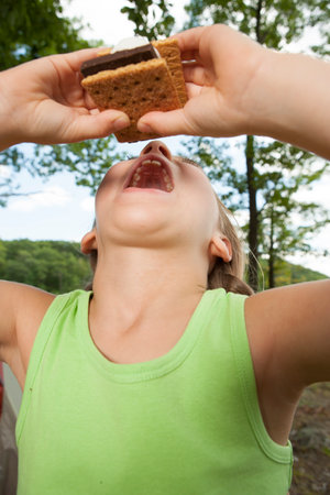 Child eating smore snack on camping tripの写真素材
