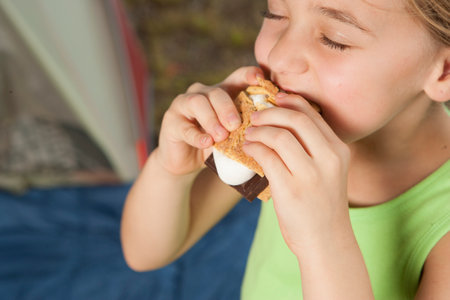 Child eating smore snack on camping tripの写真素材