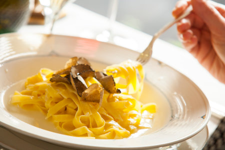 Person eating pasta at restaurantの写真素材