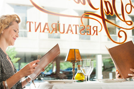 Couple looking at menu in restaurantの写真素材