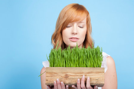 Young woman with grass in studioの写真素材