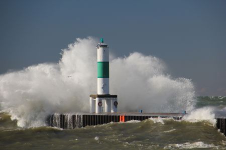 A shipping channel marker overwhelmed by a huge wave