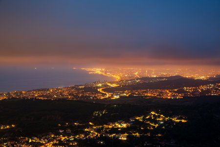 sunset on the Barcelona el Maresme coast. We can see the exit motorway to the north of Barcelona. And the towns of Alella, Masnou, Montgat, Badalona and in the background Barcelona.の写真素材