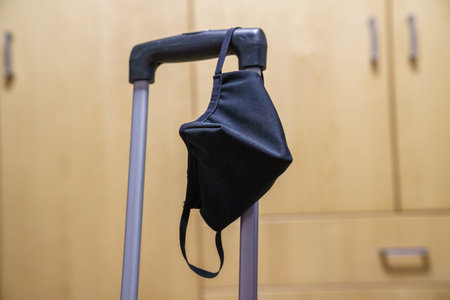 Travel suitcase prepared in times of pandemic. With the mask.の写真素材