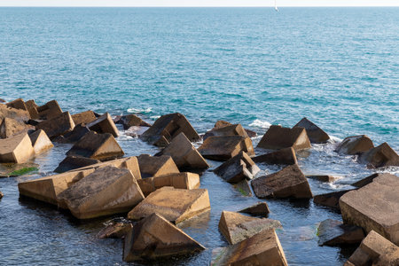 Artificial rocks forming a breakwater. Mediterranean sea, a sunny winter dayの写真素材