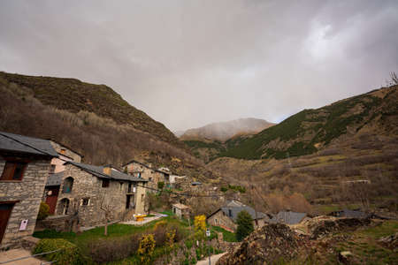 Village of Cabdella, in the Dark Valley in the Pyrenees. On an early spring day. In the background of the image, on the mountain, we can see a rain curtain.の写真素材