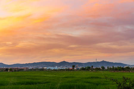 Sunset on the mountain of Collserola in Barcelona. From the Llobregat delta. We can see the silhouette of the communications antenna and the Tibidabo amusement park.の写真素材