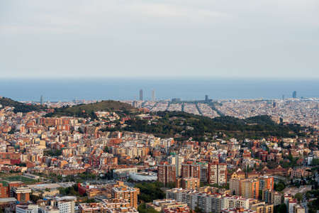 Panoramic view of the city of Barcelona from the viewpoint of LArrabassada. During sunset, a spring day. The sky is completely covered with clouds.の写真素材