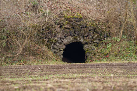 Winter landscape in the forest of La Garrotxa. Empty roads in the middle of the woods. Stone cave.