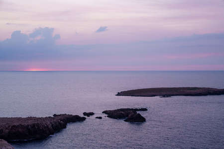 Far de Cavalleria, Menorca. September 2021. Wonderful sunset over the Mediterranean Sea from the island of Menorca.の写真素材