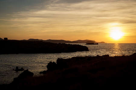 Cala Viola de Ponent, Menorca. September 2021. Magnificent sunset in the Mediterranean Sea. On one of the paradisaical beaches of the island of Menorca.の写真素材