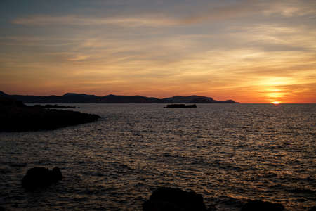 Cala Viola de Ponent, Menorca. September 2021. Magnificent sunset in the Mediterranean Sea. On one of the paradisaical beaches of the island of Menorca.の写真素材