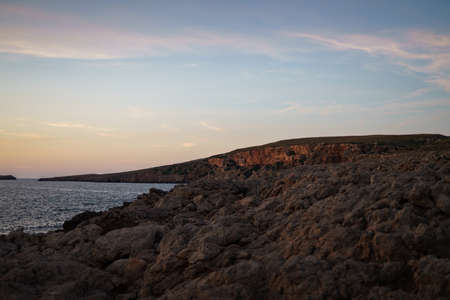 Cala Viola de Ponent, Menorca. September 2021. Magnificent sunset in the Mediterranean Sea. On one of the paradisaical beaches of the island of Menorca.の写真素材