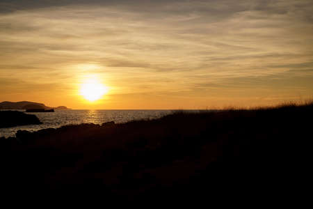 Cala Viola de Ponent, Menorca. September 2021. Magnificent sunset in the Mediterranean Sea. On one of the paradisaical beaches of the island of Menorca.の写真素材