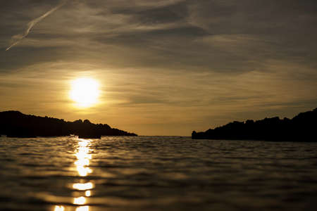 Cala Viola de Ponent, Menorca. September 2021. Magnificent sunset in the Mediterranean Sea. On one of the paradisaical beaches of the island of Menorca.の写真素材