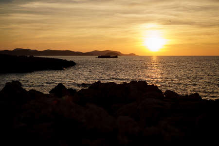 Cala Viola de Ponent, Menorca. September 2021. Magnificent sunset in the Mediterranean Sea. On one of the paradisaical beaches of the island of Menorca.の写真素材