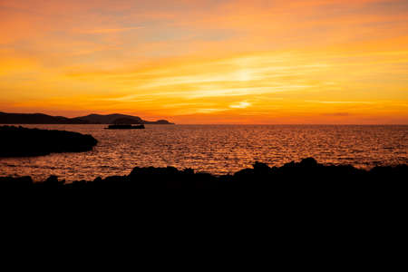 Cala Viola de Ponent, Menorca. September 2021. Magnificent sunset in the Mediterranean Sea. On one of the paradisaical beaches of the island of Menorca.の写真素材