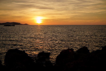Cala Viola de Ponent, Menorca. September 2021. Magnificent sunset in the Mediterranean Sea. On one of the paradisaical beaches of the island of Menorca.の写真素材