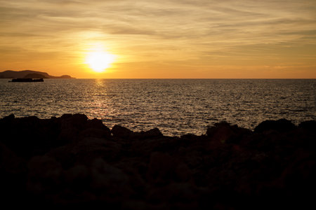 Cala Viola de Ponent, Menorca. September 2021. Magnificent sunset in the Mediterranean Sea. On one of the paradisaical beaches of the island of Menorca.の写真素材
