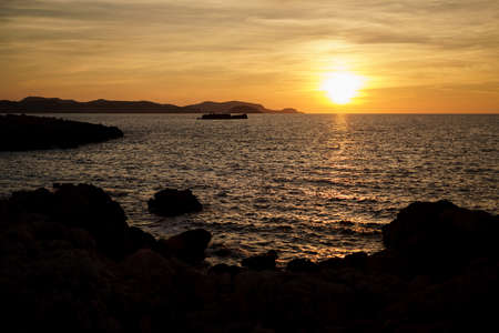 Cala Viola de Ponent, Menorca. September 2021. Magnificent sunset in the Mediterranean Sea. On one of the paradisaical beaches of the island of Menorca.の写真素材