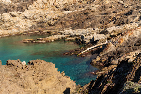 Cap de Creus Alt Emporda, Spain. February 2023 Rugged rocky coastline with turquoise waters in contrast. Sharp rocks extend out to the sea, creating a dramatic and wild texture.の写真素材