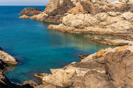 Cap de Creus Alt Emporda, Spain. February 2023 Rugged rocky coastline with turquoise waters in contrast. Sharp rocks extend out to the sea, creating a dramatic and wild texture.の写真素材